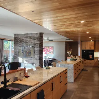A lower Tasmanian Oak lined ceiling delineates the kitchen/bar area from dining/living areas